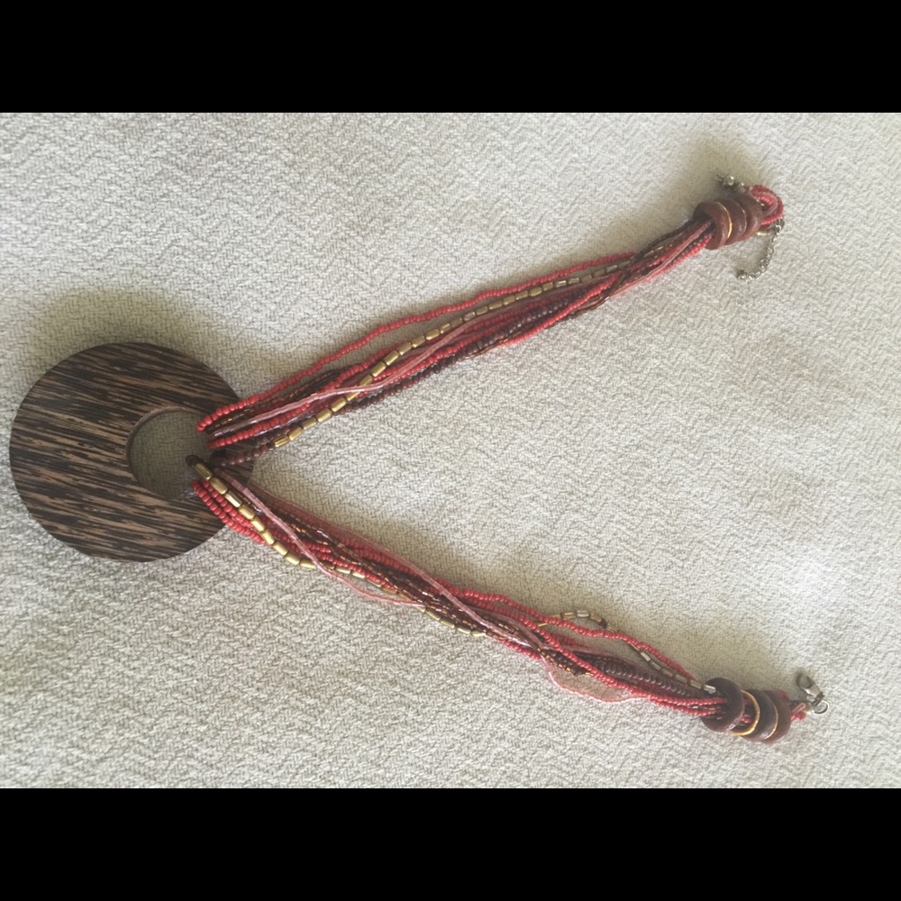 Necklace. Orange/brown colors. Wood medallion